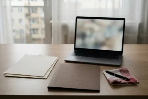Dokumenty i laptop na spokojnie oświetlonym biurku